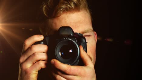 Animation-of-light-over-caucasian-male-photographer-with-camera-on-black-background