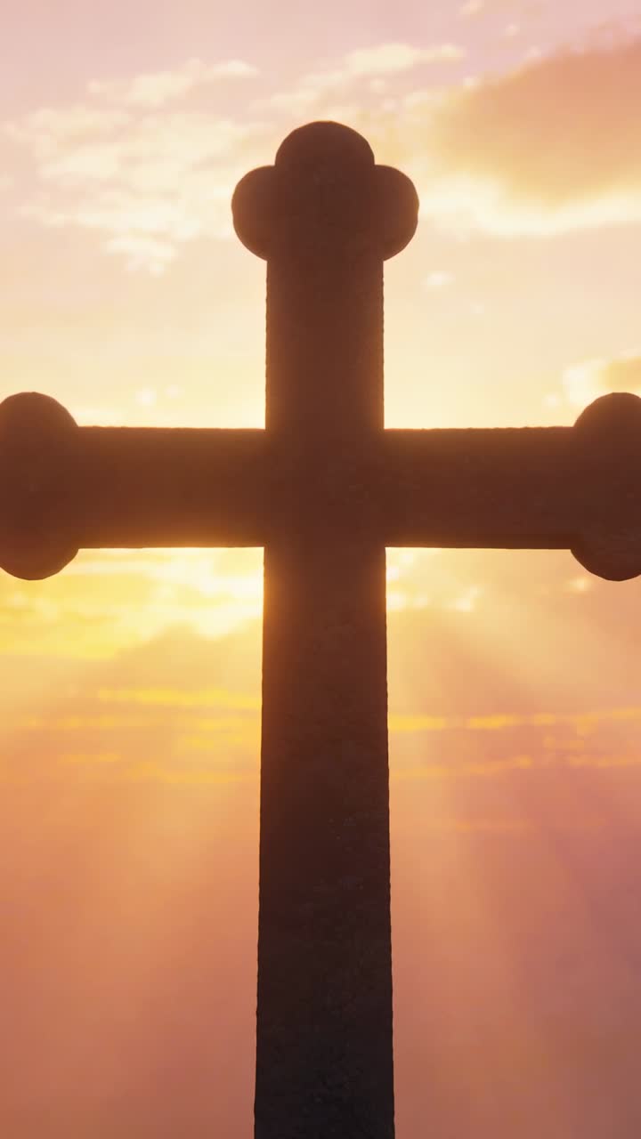 Croce ornata in silhouette mentre il sole si sposta dietro, proiettando raggi rosa-dorati, per arte religiosa.