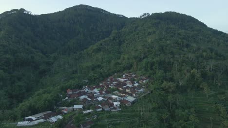 fotografía de un avión no tripulado de un paisaje rural con vistas a un pueblo remoto en colinas boscosas