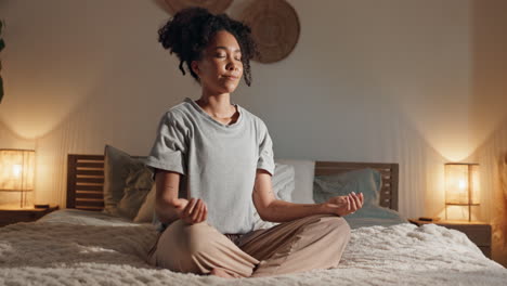 woman meditating in her bedroom at night