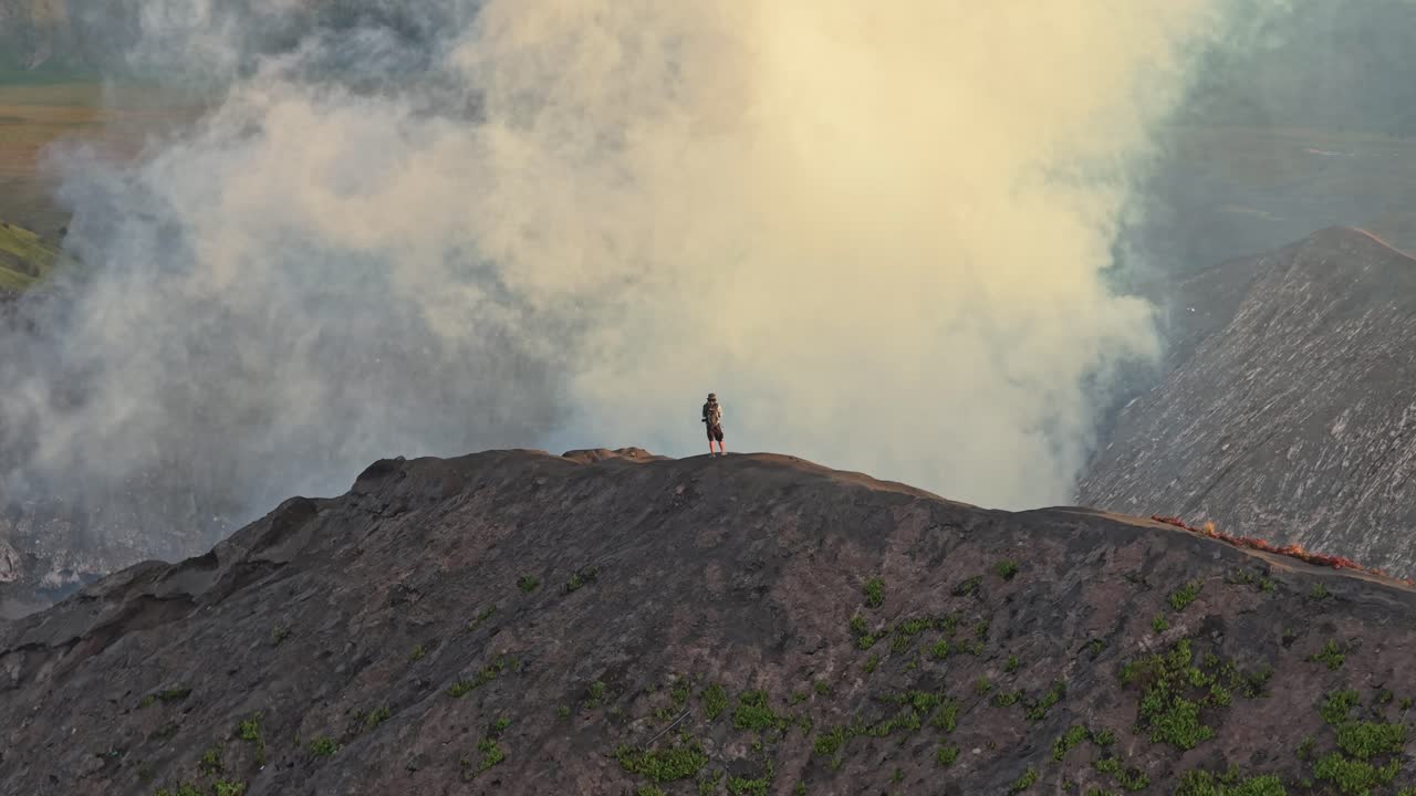 Turista solitario in piedi sul bordo del cratere del vulcano Monte Bromo