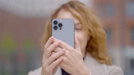 woman taking picture with smartphone outdoors