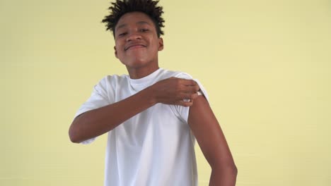 african american teenager showing covid-19 vaccine bandage merrily