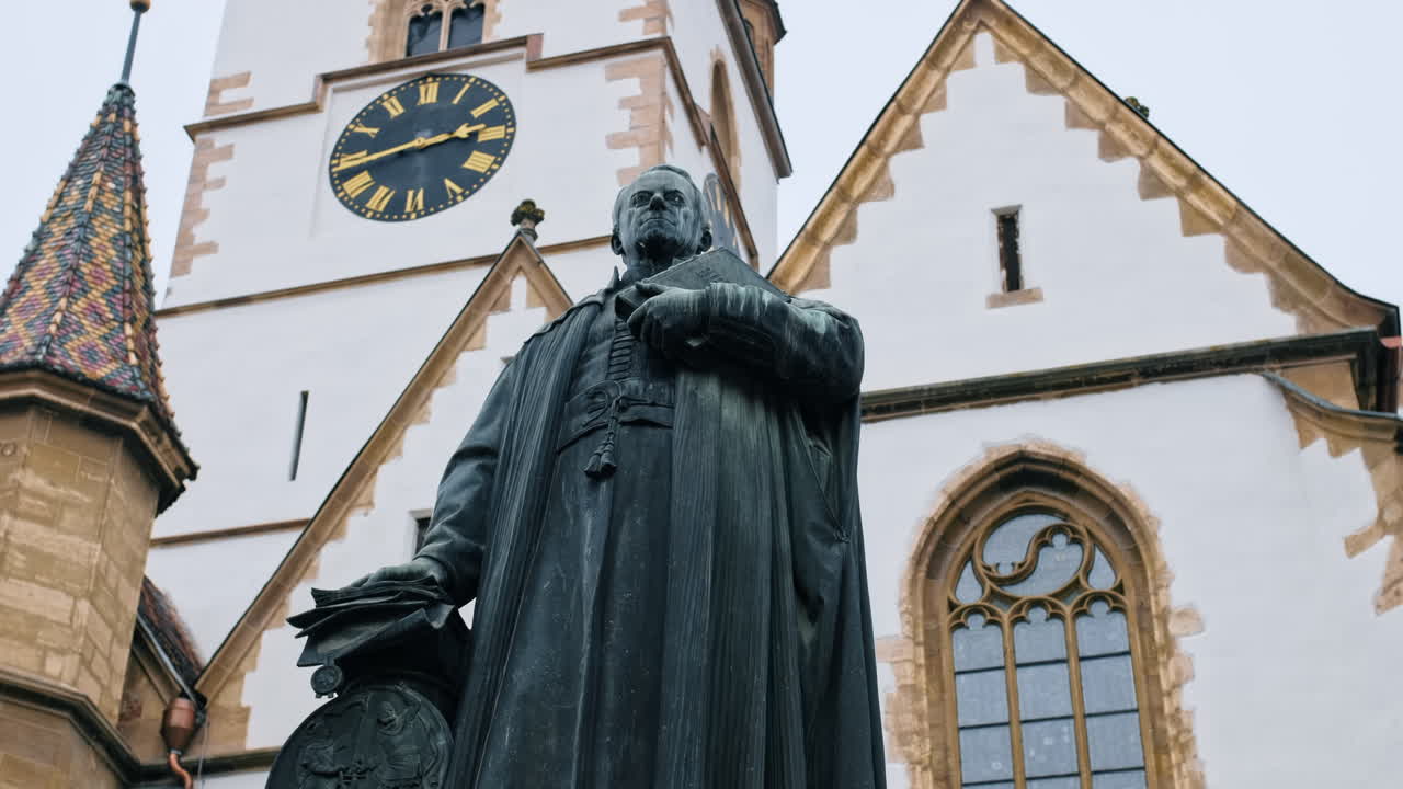 Statue of Bishop Georg Daniel Teutsch in Sibiu, Romania. Sibiu Lutheran Cathedral on the background
