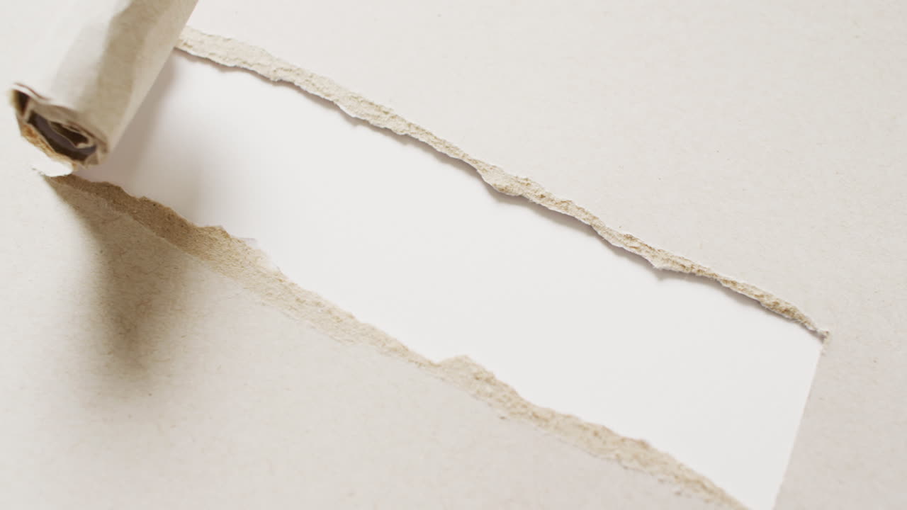 ⁇ 색 바탕에  ⁇ 어진 베이지 종이 조각의 클로즈업 비디오