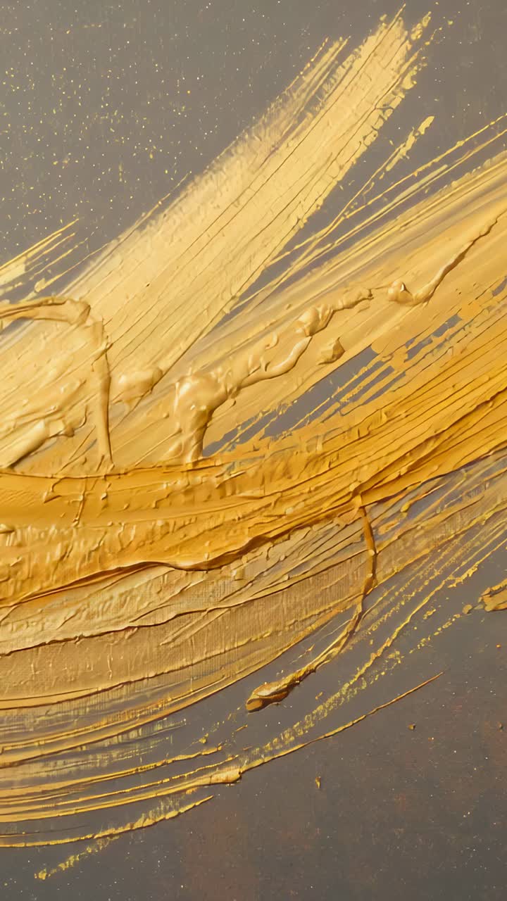 Vertical video: Displaying fresh gold paint stroke settling, smoothing on dark speckled panel