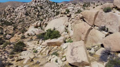 side drone flying in rocky desert with stone boulders