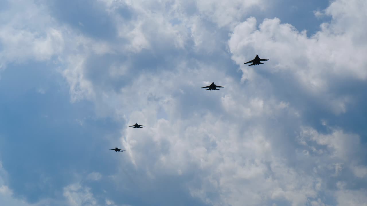 Four jets approach in slow motion to attack and maneuver while flying close up.
