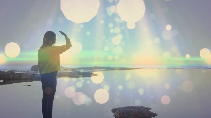 Woman turning shading eyes as sun nearing scanning horizon bokeh and flare round her for health