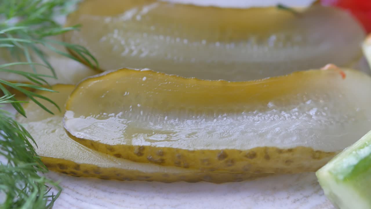 Close up of a plate with pickled cucumbers and fresh dill