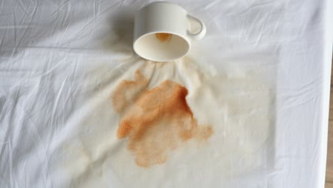 café derramado en la sábana blanca