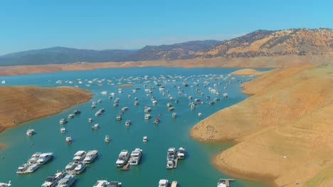 Increíble-Antena-Sobre-El-Lago-Oroville-De-California-Azotado-Por-La-Sequía-Con-Bajos-Niveles-De-Agua,-Costa-En-Retroceso-Y-Casas-Flotantes-Varadas