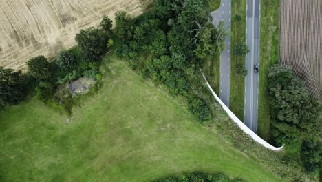 Aerial-top-down-following-a-road-traversed-by-natural-corridor-wildlife-crossing-bridge-for-animals-to-migrate-between-conservancy-areas