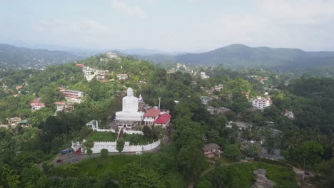 Aerial-orbits-big-white-Buddha-statue,-Bahirawakanda-vihara,-Sri-Lanka