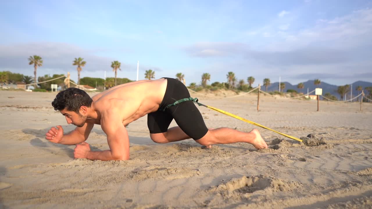 actividad de resistencia arrastrando un timbre unido a una banda elástica arrastrándose por la arena