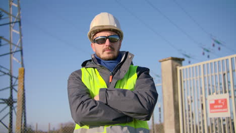 shift worker standing waiting outside secured high voltage substation