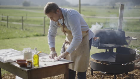 man preparing pizza dough outdoors