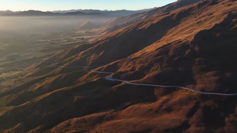 winding road over the mountains of crown range to cardrona, new zealand