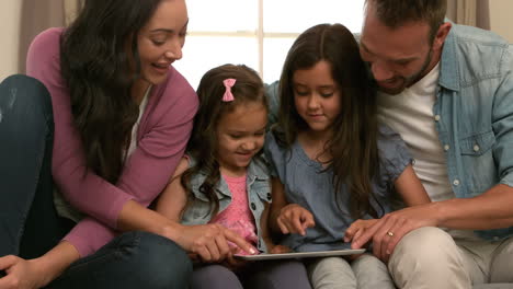 familia feliz usando la tableta en el sofá