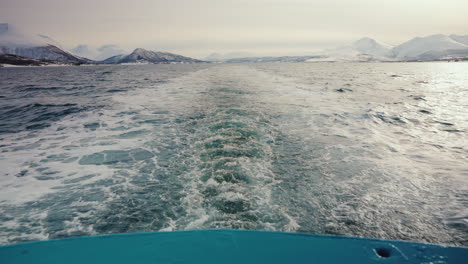 wide static shot of boat cruise sailing along the arctic fjords in norway