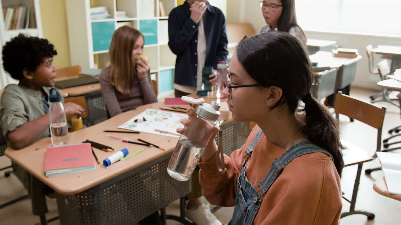 Students drinking and eating during a break in a classroom