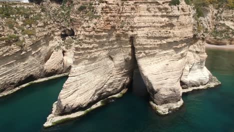 Disparo-De-Grúa-Que-Se-Levanta-Revelando-El-Hermoso-Paisaje-Urbano-De-Beirut-Detrás-De-Enormes-Rocas-De-Paloma-Rawshe,-Líbano