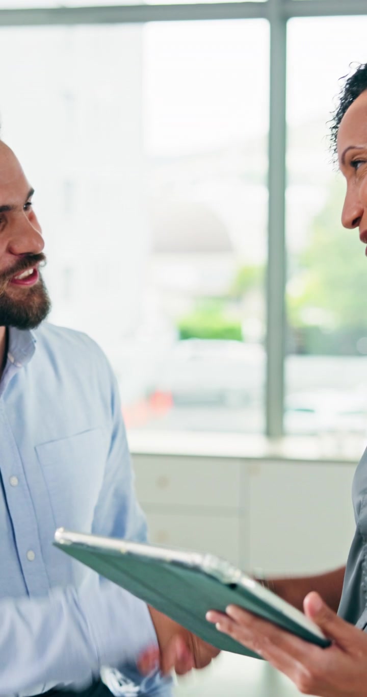 Business Colleagues Discussing Project on Tablet and Shaking Hands in Office