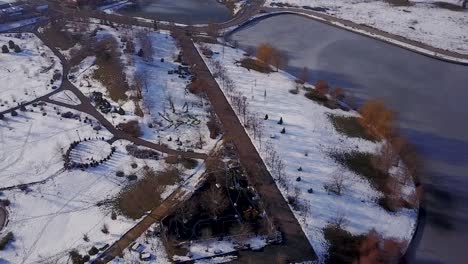 Flug-Durch-Den-Park-Von-Mogosoaia,-Bukarest,-Neben-Einem-Perfekt-Zugefrorenen-See