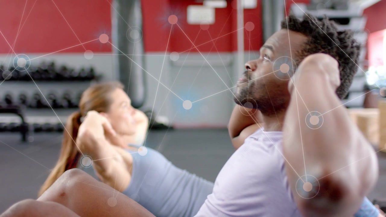 Gym partners starting fitness set, doing crunches on mats with network overlay tracking motion