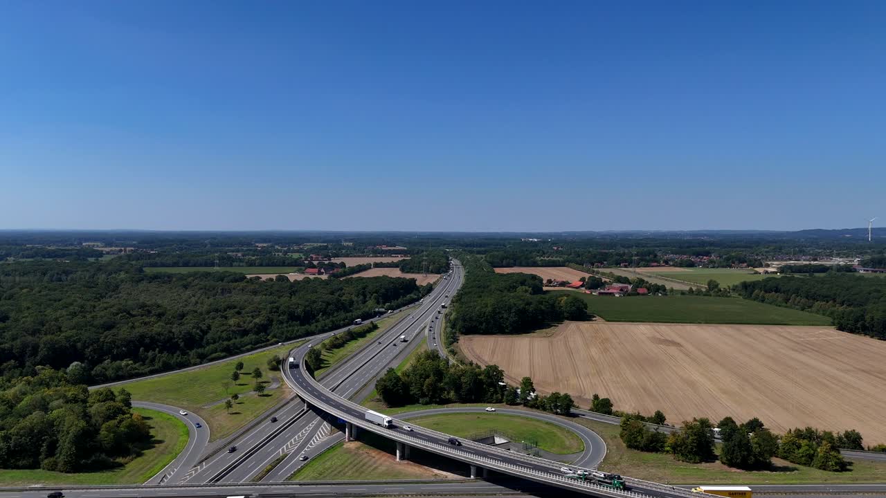 Elevated highway with cars in America. Aerial wide shot. Traffic scene. Agricultural farm fields in countryside of USA. Panorama. New build congestion and multi-lane interstate road