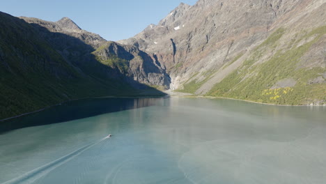 Naturaleza-Serena-Con-Barco-Navegando-En-Un-Fiordo-Rodeado-De-Montañas-Cerca-De-Tromso,-Noruega