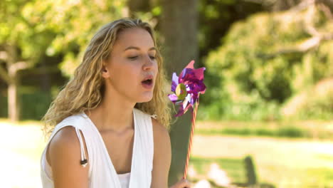 blonde blowing on a pinwheel in slow motion