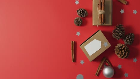 decoraciones de navidad con conos de pino, palitos de canela y espacio de copia sobre fondo rojo