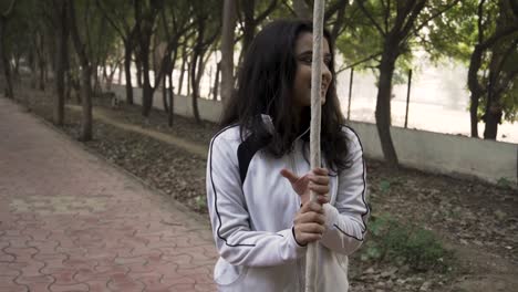 una gimnasta deportiva realiza ejercicios con una cuerda en ropa deportiva