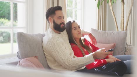 Video-of-happy-caucasian-couple-siting-on-sofa-and-watching-tv