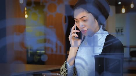 digital icons moving against woman talking on a smartphone