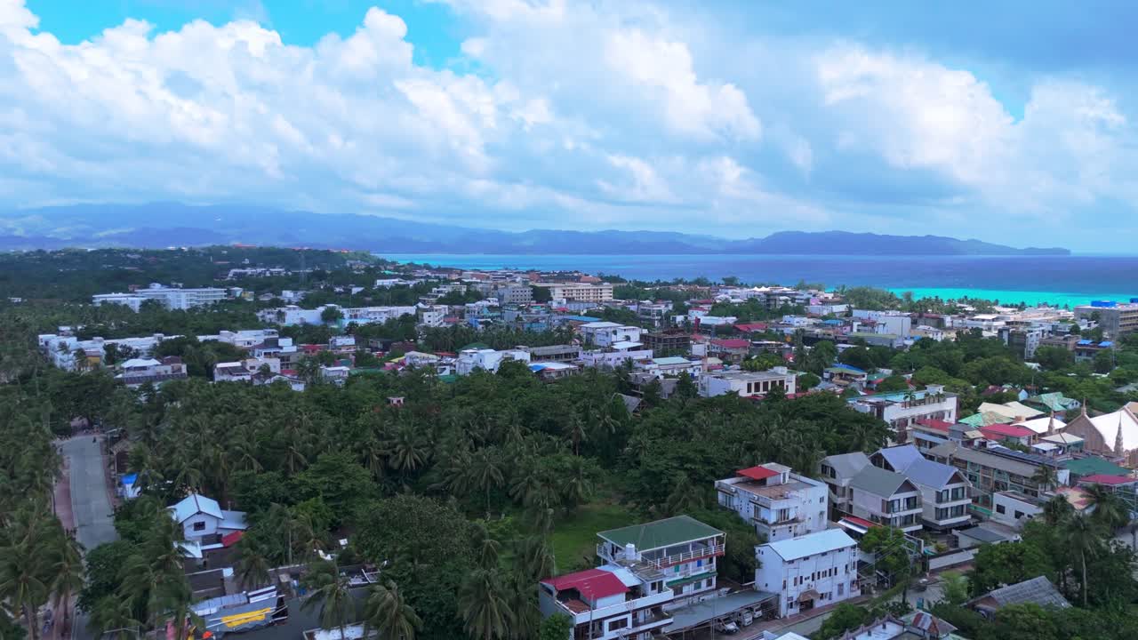 4K drone footage of Boracay’s urban center with lush trees, mountains, and crystal-clear coastline—ideal for real estate, travel, or cityscape content