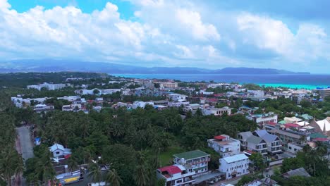 4k drone footage of boracay’s urban center with lush trees, mountains, and crystal-clear coastline—ideal for real estate, travel, or cityscape content