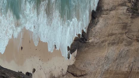 Toma-Vertical-Estática-Con-Zoom-De-La-Playa-De-Diamantes-En-La-Isla-De-Nusa-Penida-Bali-Que-Muestra-Las-Arenas-Blancas,-El-Agua-Azul-Y-Las-Olas-Rompiendo-En-La-Playa