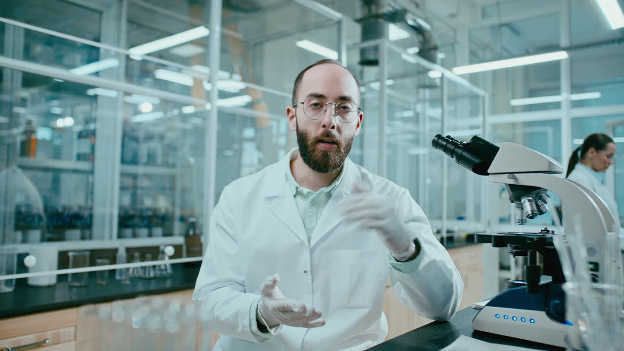 Professional Male Scientist Explaining Research Process on Camera in Laboratory