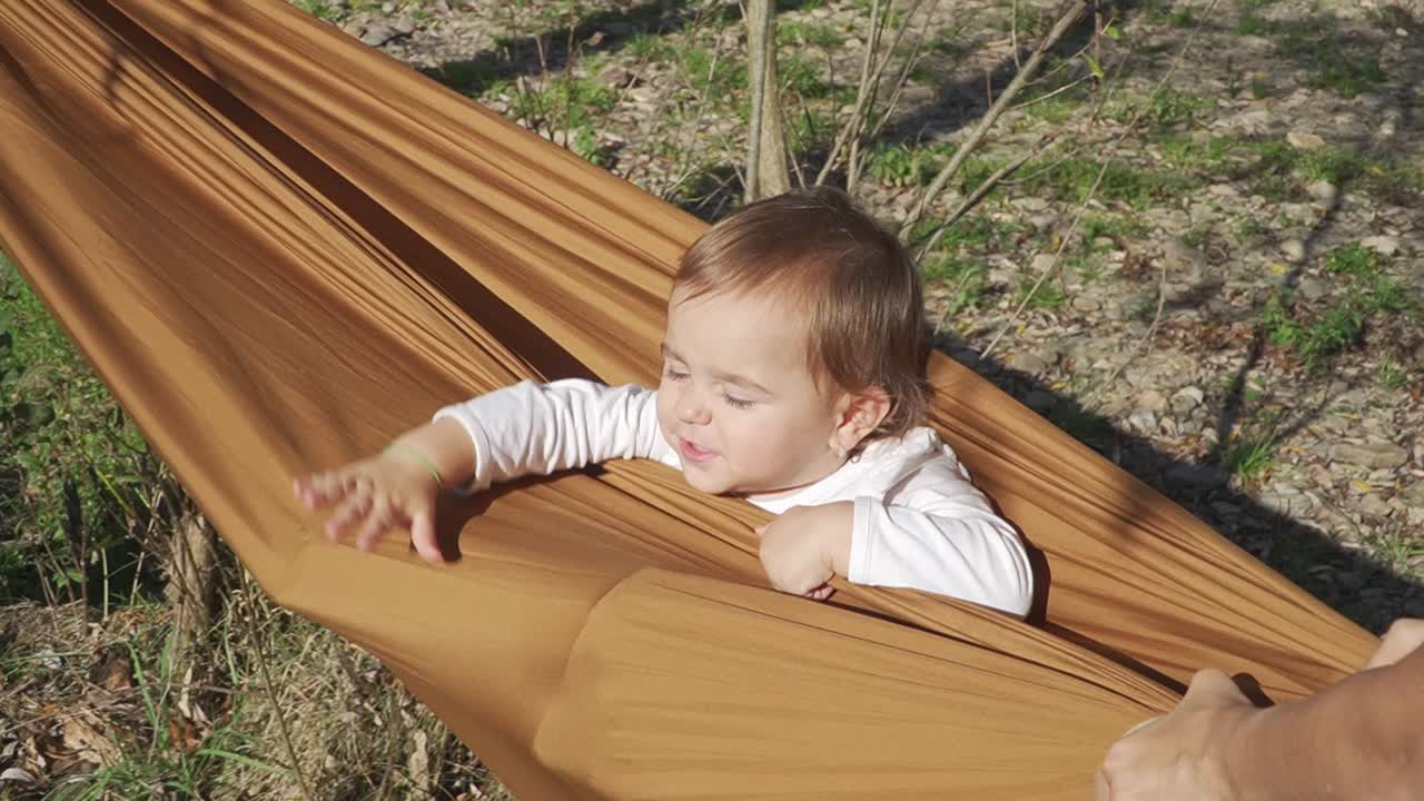 Close up view of little girl swinging in hammock