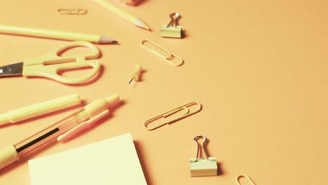 close up of school stationery on orange background, in slow motion