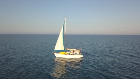 Orbit-Shot-Of-Beautiful-Sailing-Boat-Middle-Of-Blue-Ocean-In-Sunny-Day,-Larnaca-City,-Cyprus