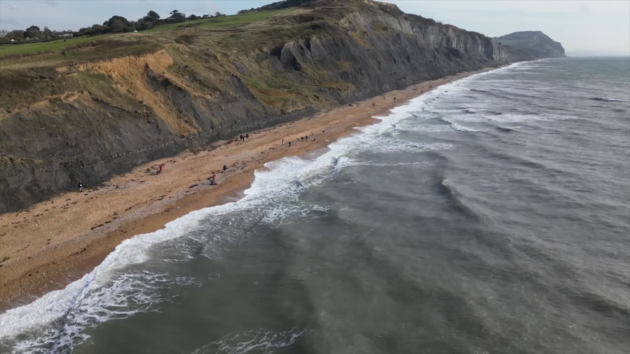 Aerial jib up of the incredible Charmouth Beach with its massive cliff sides