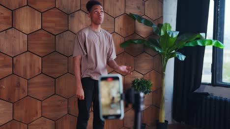un joven afroamericano realiza una danza moderna grabada en un teléfono móvil.