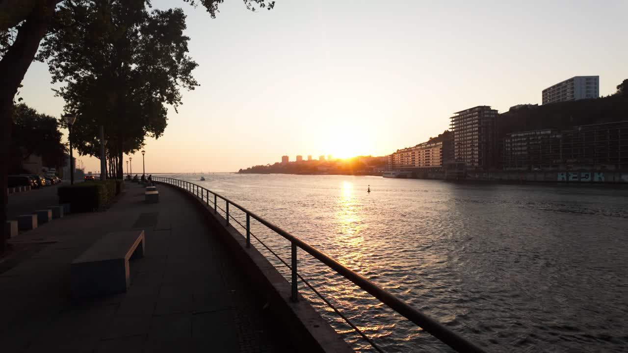 Colorful buildings line the Douro River promenade in Vila Nova de Gaia at dusk, Porto, Portugal