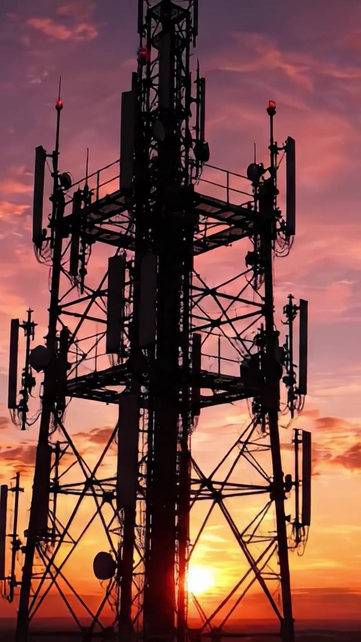 Silhouette di una Torre Contro un Cielo Vibrante al Tramonto: Connettendo il Mondo, un Segnale alla Volta, Mentre il Giorno si Trasforma in Notte