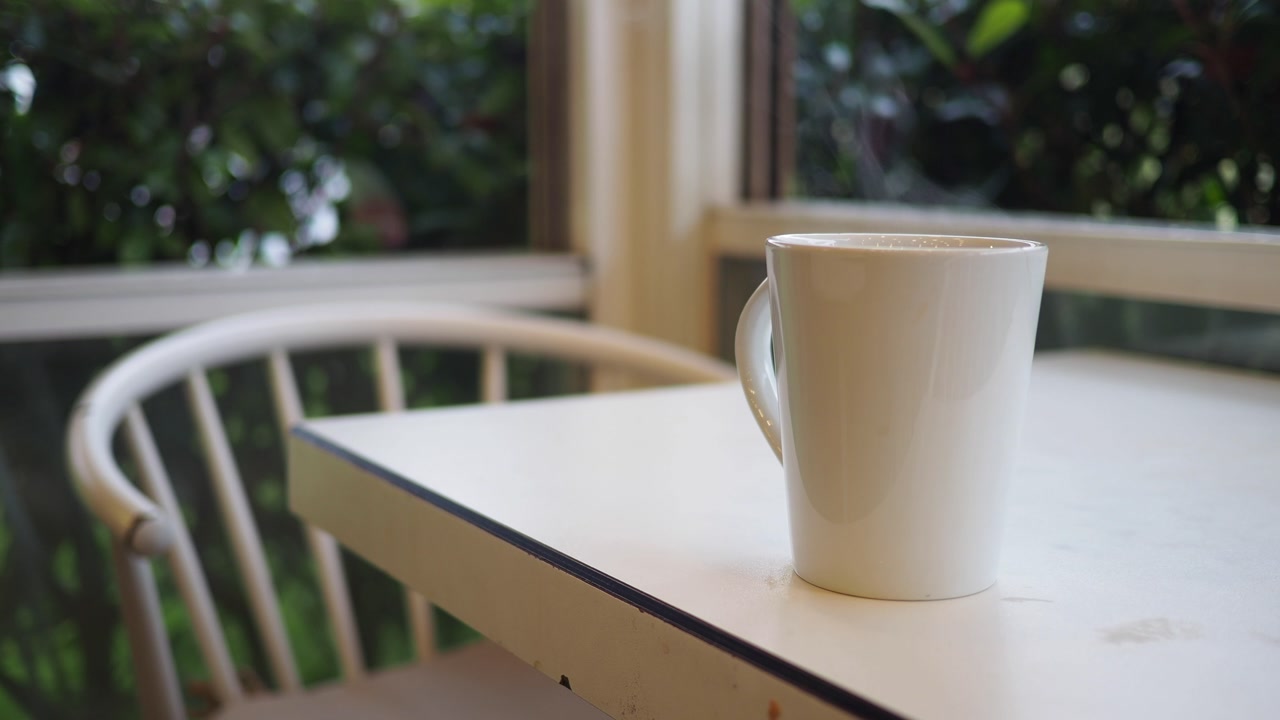 Steaming Hot Drink in a White Mug on a Table by a Window