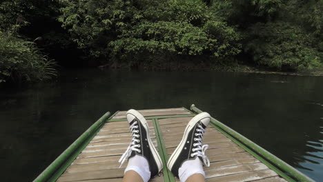 boot mit männlichen füßen, das in trang, vietnam, segelt