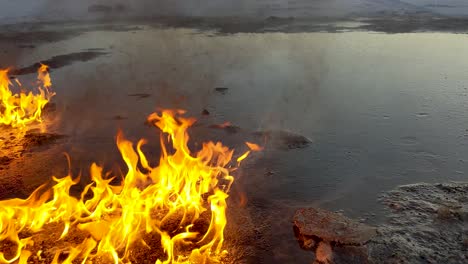 burning oil spill slowly melts surrounding snow as the sun rises in the back ground